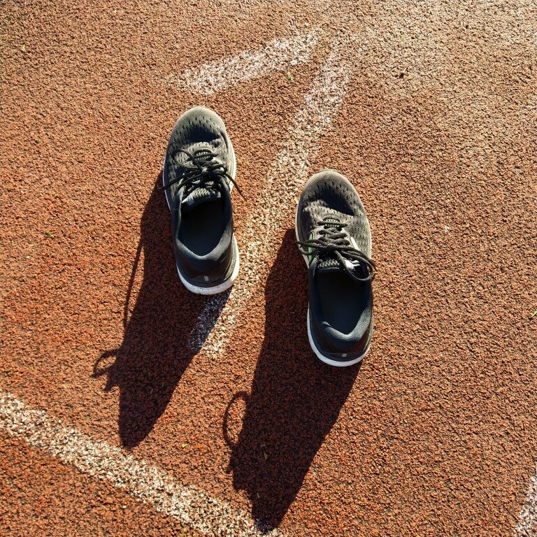 Wie het schoentje past: loopschoenen op een atletiekpiste. 