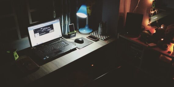 black laptop beside black computer mouse inside room