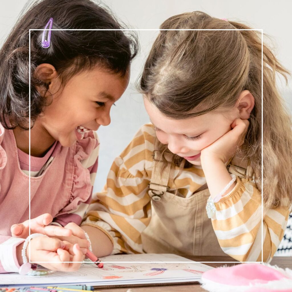 kinderen aan de kunst. Twee meisjes kleuren samen in een boek