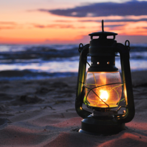 Een brandende lamp op het strand
