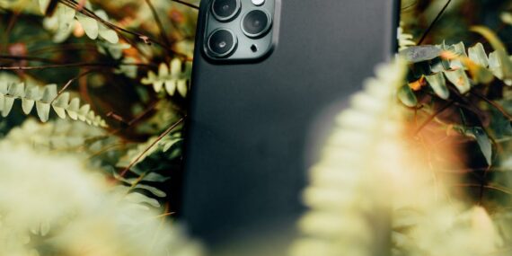 black smartphone surrounded with plants